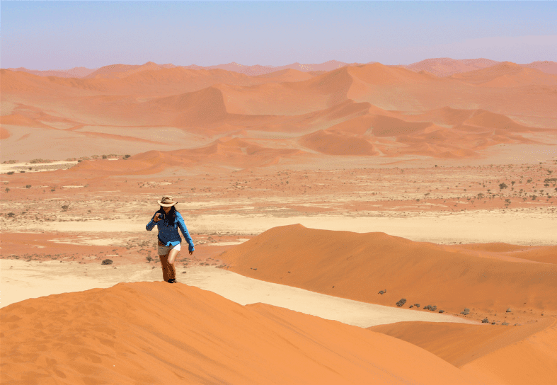Volunteer in Namibia climbing sand dune