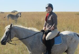 Horse riding volunteer with zebra