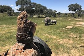 Nature enthusiast student watching rhinos