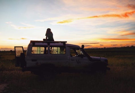 volunteer sitting on vehicle at sunset