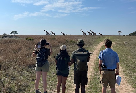 Nature Enthusiast students standing in front of giraffes